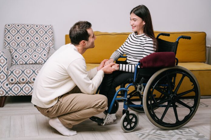 Begeleider ondersteunt een cliënt in een rolstoel in een huiselijke zorgsetting