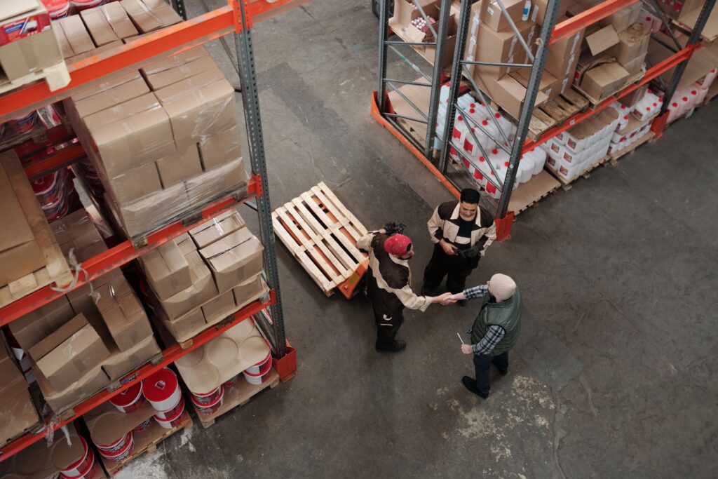Twee magazijnmedewerkers in gesprek over samenwerking, symbolisch voor de veranderende inhuurmarkt door de Wet meer zekerheid flexwerkers