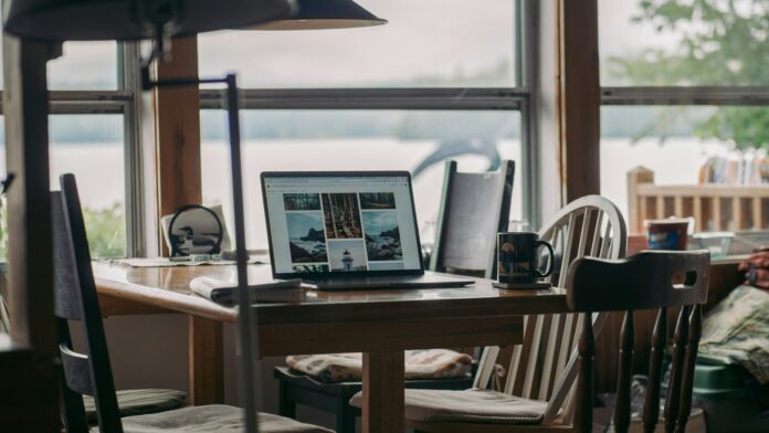 Geopende laptop op tafel in een vakantiehuis met uitzicht op het water